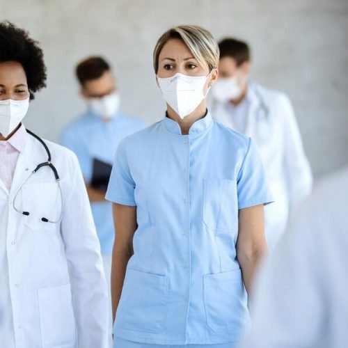 female-doctor-nurse-with-face-masks-walking-though-corridor-hospital_637285-9093