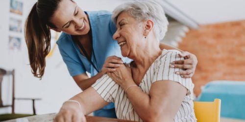 Home care healthcare professional hugging senior patient