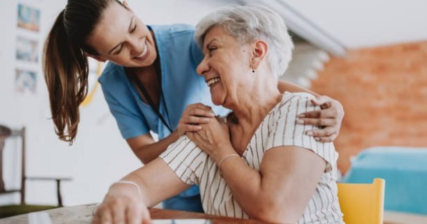 Home care healthcare professional hugging senior patient